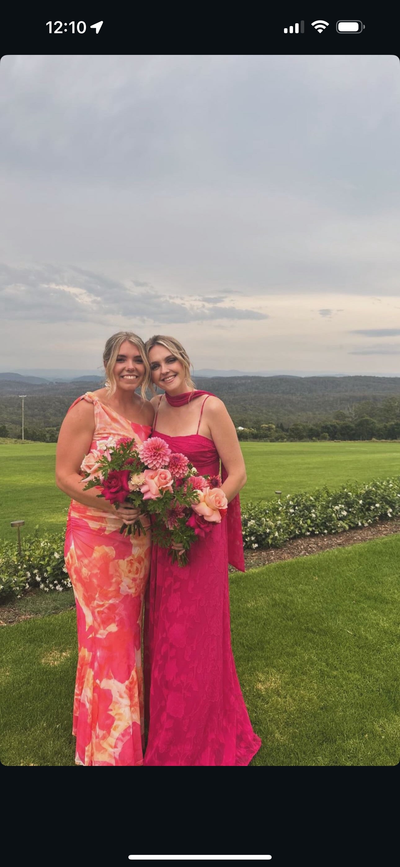 Two women in pink dresses outside The Dairy Ravensbourne. Holding wedding bridesmaid bouquets